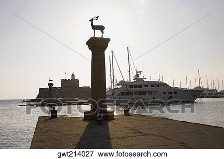 Low angle view of a monument, Mandraki Harbor, Rhodes, Dodecanese Islands, Greece View Large Photo Image Stock Photo - Low angle view of a monument, Mandraki Harbor, Rhodes, Dodecanese Islands, Greece. Fotosearch