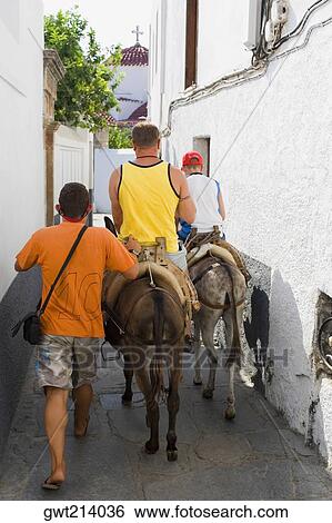 Rear view of tourists horseback riding, Rhodes, Dodecanese Islands, Greece View Large Photo Image Stock Photograph - Rear view of tourists horseback riding, Rhodes, Dodecanese Islands, Greece. Fotosearch