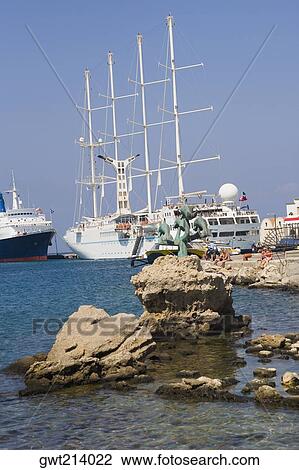 Stock Image - Sailing ships at a harbor, Mandraki Harbor, Rhodes, Dodecanese Islands, Greece. Fotosearch