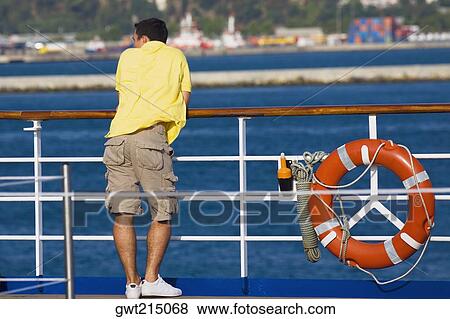 Stock Photo - Rear view of a man leaning against a railing. Fotosearch