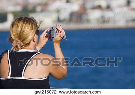 Rear view of a mature woman using a home video camera, Athens, Greece View Large Photo Image Stock Image - Rear view of a mature woman using a home video camera, Athens, Greece. Fotosearch