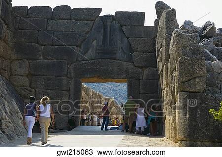 Stock Image - Tourists at an old ruin, Lion Gate, Mycenae, Peloponnese, Athens, Greece. Fotosearch