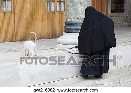 Rear view of a Muslim woman in hijab standing with a cat, Istanbul, Turkey View Large Photo Image Stock Image - Rear view of a Muslim woman in hijab standing with a cat, Istanbul, Turkey. Fotosearch