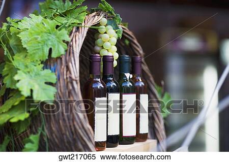 Close-up of four bottles of wine with a bunch of grapes, Greece View Large Photo Image Stock Photography - Close-up of four bottles of wine with a bunch of grapes, Greece. Fotosearch