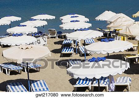 High angle view of lounge chairs and beach umbrellas on the beach, Greece View Large Photo Image Stock Image - High angle view of lounge chairs and beach umbrellas on the beach, Greece. Fotosearch