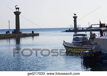 Stock Image - Monuments in the sea, Mandraki Harbor, Rhodes, Dodecanese Islands, Greece. Fotosearch