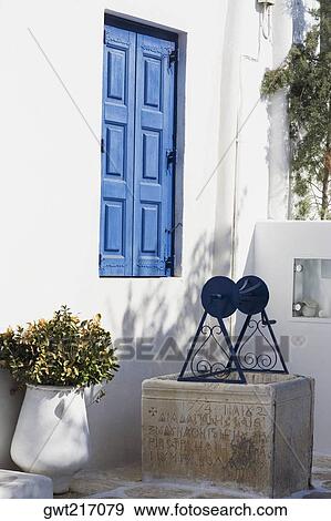 Potted plant and a well in front of a house, Greece View Large Photo Image Stock Photo - Potted plant and a well in front of a house, Greece. Fotosearch