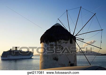Traditional windmill on the coast with a cruise ship in the background, Mykonos, Cyclades Islands, Greece View Large Photo Image Stock Image - Traditional windmill on the coast with a cruise ship in the background, Mykonos, Cyclades Islands, Greece. Fotosearch
