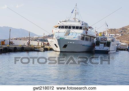 Stock Image - Cruise ship docked at a harbor, Mykonos, Cyclades Islands, Greece. Fotosearch