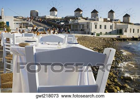 Tables and chairs in a restaurant at the coast, Mykonos, Cyclades Islands, Greece View Large Photo Image Stock Image - Tables and chairs in a restaurant at the coast, Mykonos, Cyclades Islands, Greece. Fotosearch