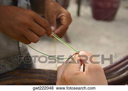 Stock Photo - Close-up of two people's hands holding wires. Fotosearch