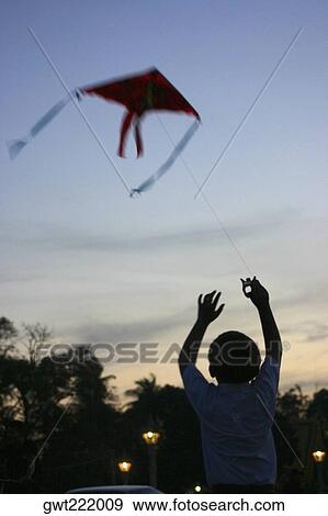 Rear view of a boy flying a kite, Phnom Penh, Cambodia View Large Photo Image Stock Photo - Rear view of a boy flying a kite, Phnom Penh, Cambodia. Fotosearch
