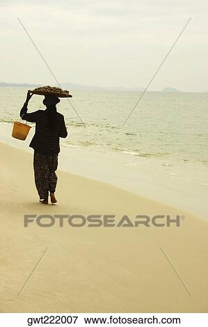 Rear view of a woman walking on the beach, Sihanoukville, Cambodia View Large Photo Image Stock Photo - Rear view of a woman walking on the beach, Sihanoukville, Cambodia. Fotosearch