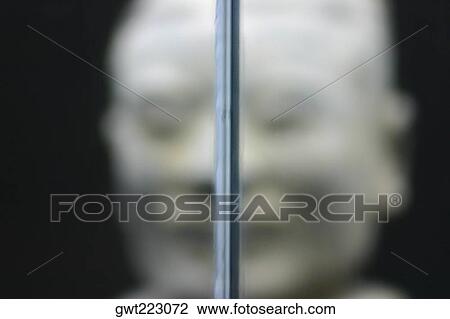 Stock Image - Close-up of a metal rod and a statue in the background, Xi'an, Shaanxi Province, China. Fotosearch