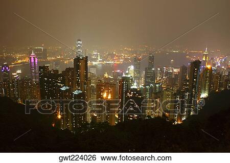 Stock Photograph - High angle view of skyscrapers lit up at night in a city, Victoria Harbor, Hong Kong Island, Hong Kong, China. Fotosearch