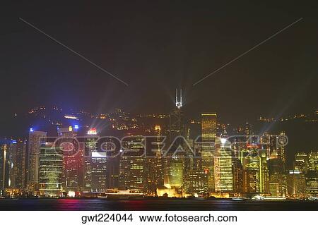 Picture - Skyscrapers lit up at night in a city, Victoria Harbor, Hong Kong Island, Hong Kong, China. Fotosearch