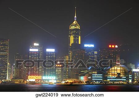 Stock Photo - Skyscrapers lit up at night in a city, Victoria Harbor, Hong Kong Island, Hong Kong, China. Fotosearch