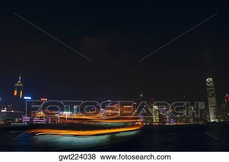 Stock Photo - Skyscrapers lit up at night in a city, Victoria Harbor, Hong Kong Island, Hong Kong, China. Fotosearch