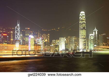 Skyscrapers lit up at night in a city, Victoria Harbor, Hong Kong Island, Hong Kong, China View Large Photo Image Stock Photo - Skyscrapers lit up at night in a city, Victoria Harbor, Hong Kong Island, Hong Kong, China. Fotosearch