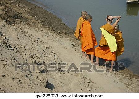 High angle view of four monks standing at the riverbank, Luang Prabang, Laos View Large Photo Image Stock Image - High angle view of four monks standing at the riverbank, Luang Prabang, Laos. Fotosearch