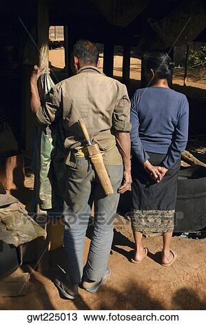 Stock Image - Rear view of a man standing with a woman, Phonsavan, Laos. Fotosearch