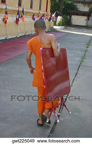 Rear view of a monk carrying a folded table and walking on the road, Vientiane, Laos View Large Photo Image Stock Photo - Rear view of a monk carrying a folded table and walking on the road, Vientiane, Laos. Fotosearch