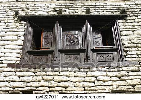 Stock Image - Low angle view of a window on a stone wall, Ghorapani, Annapurna Range, Himalayas, Nepal. Fotosearch
