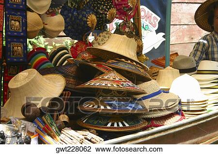 Stock Image - Hats on a market stall, Floating Market, Thailand. Fotosearch