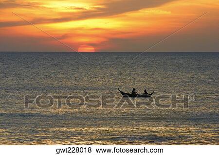 Stock Photo - Silhouette of two people rowing a boat in the sea, Ko Lanta, Thailand. Fotosearch
