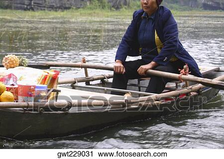 Female vendor in a boat at a floating market, Dong Hoi, Vietnam View Large Photo Image Stock Image - Female vendor in a boat at a floating market, Dong Hoi, Vietnam. Fotosearch