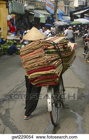 Rear view of a man selling rugs in a market, Hanoi, Vietnam View Large Photo Image Picture - Rear view of a man selling rugs in a market, Hanoi, Vietnam. Fotosearch