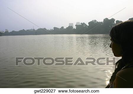 Side profile of a young woman looking in river, Hanoi, Vietnam View Large Photo Image Stock Photo - Side profile of a young woman looking in river, Hanoi, Vietnam. Fotosearch