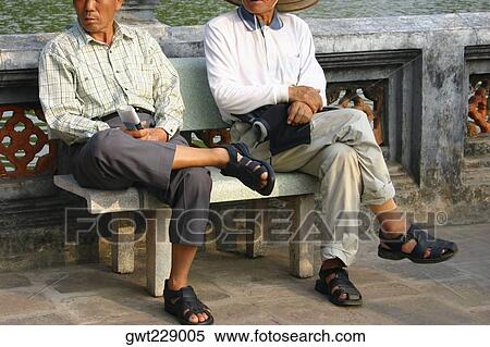 Two mature men sitting on a bench, Hanoi, Vietnam View Large Photo Image Stock Photography - Two mature men sitting on a bench, Hanoi, Vietnam. Fotosearch