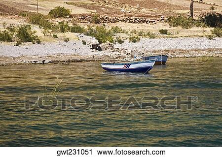 Boats in a lake, Lake Titicaca, Puno, Puno Region, Puno Province, Peru View Large Photo Image Stock Image - Boats in a lake, Lake Titicaca, Puno, Puno Region, Puno Province, Peru. Fotosearch