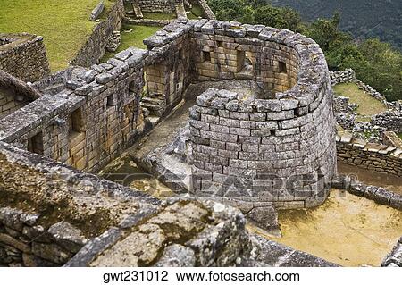 Stock Image - High angle view of the ruins of a temple, Temple of The Sun, Machu Picchu, Urubamba Valley, Cuzco, Peru. Fotosearch