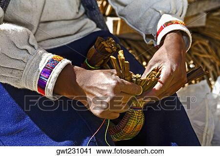Mid section view of a woman weaving a basket, Uros Floating Islands, Puno, Peru View Large Photo Image Stock Image - Mid section view of a woman weaving a basket, Uros Floating Islands, Puno, Peru. Fotosearch