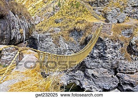 Stock Photography - High angle view of a rope bridge across a mountain, Queswachaca, Peru. Fotosearch