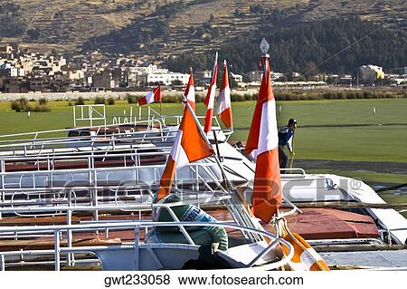 Close-up of Peruvian flags on boats in a lake, Lake Titicaca, Puno, Peru View Large Photo Image Stock Photo - Close-up of Peruvian flags on boats in a lake, Lake Titicaca, Puno, Peru. Fotosearch