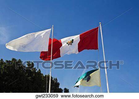 Stock Photo - Low angle view of flags fluttering, Plaza-De-Armas, Pisco, Ica Region, Peru. Fotosearch
