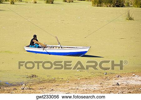 Side profile of a man sitting on a boat, Lake Titicaca, Puno, Peru View Large Photo Image Stock Photograph - Side profile of a man sitting on a boat, Lake Titicaca, Puno, Peru. Fotosearch