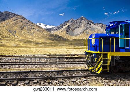 Train on a railroad track with a mountain range in the background, Puno, Peru View Large Photo Image Stock Image - Train on a railroad track with a mountain range in the background, Puno, Peru. Fotosearch