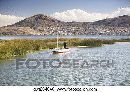 Rear view of a man standing on a boat in a lake, Lake Titicaca, Puno, Peru View Large Photo Image Stock Photograph - Rear view of a man standing on a boat in a lake, Lake Titicaca, Puno, Peru. Fotosearch