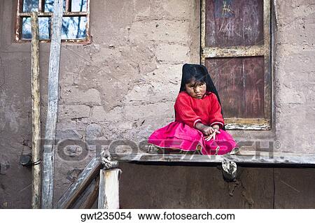 Portrait of a girl sitting in front of the gate of a house, Taquile Island, Lake Titicaca, Puno, Peru View Large Photo Image Picture - Portrait of a girl sitting in front of the gate of a house, Taquile Island, Lake Titicaca, Puno, Peru. Fotosearch