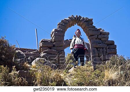 Portrait of a young woman standing under a stone arch, Taquile Island, Lake Titicaca, Puno, Peru View Large Photo Image Stock Photo - Portrait of a young woman standing under a stone arch, Taquile Island, Lake Titicaca, Puno, Peru. Fotosearch
