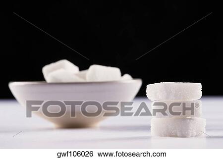 Stack of sugar cubes and a bowl of sugar cubes in the background View Large Photo Image Stock Photograph - Stack of sugar cubes and a bowl of sugar cubes in the background. Fotosearch