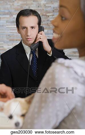 Mature man talking on the phone and a young woman holding a puppy View Large Photo Image Stock Image - Mature man talking on the phone and a young woman holding a puppy. Fotosearch
