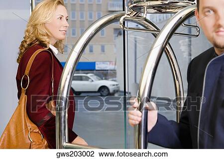 Stock Image - Mature woman with a mid adult man standing at the entrance gate. Fotosearch