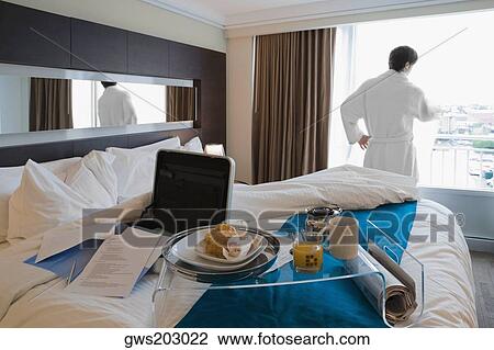 Rear view of a young man looking through a window View Large Photo Image Stock Image - Rear view of a young man looking through a window. Fotosearch