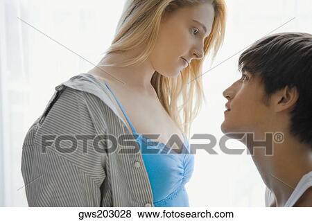 Side profile of a young couple looking at each other View Large Photo Image Stock Photo - Side profile of a young couple looking at each other. Fotosearch