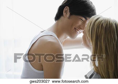 Side profile of a young couple romancing View Large Photo Image Stock Photo - Side profile of a young couple romancing. Fotosearch